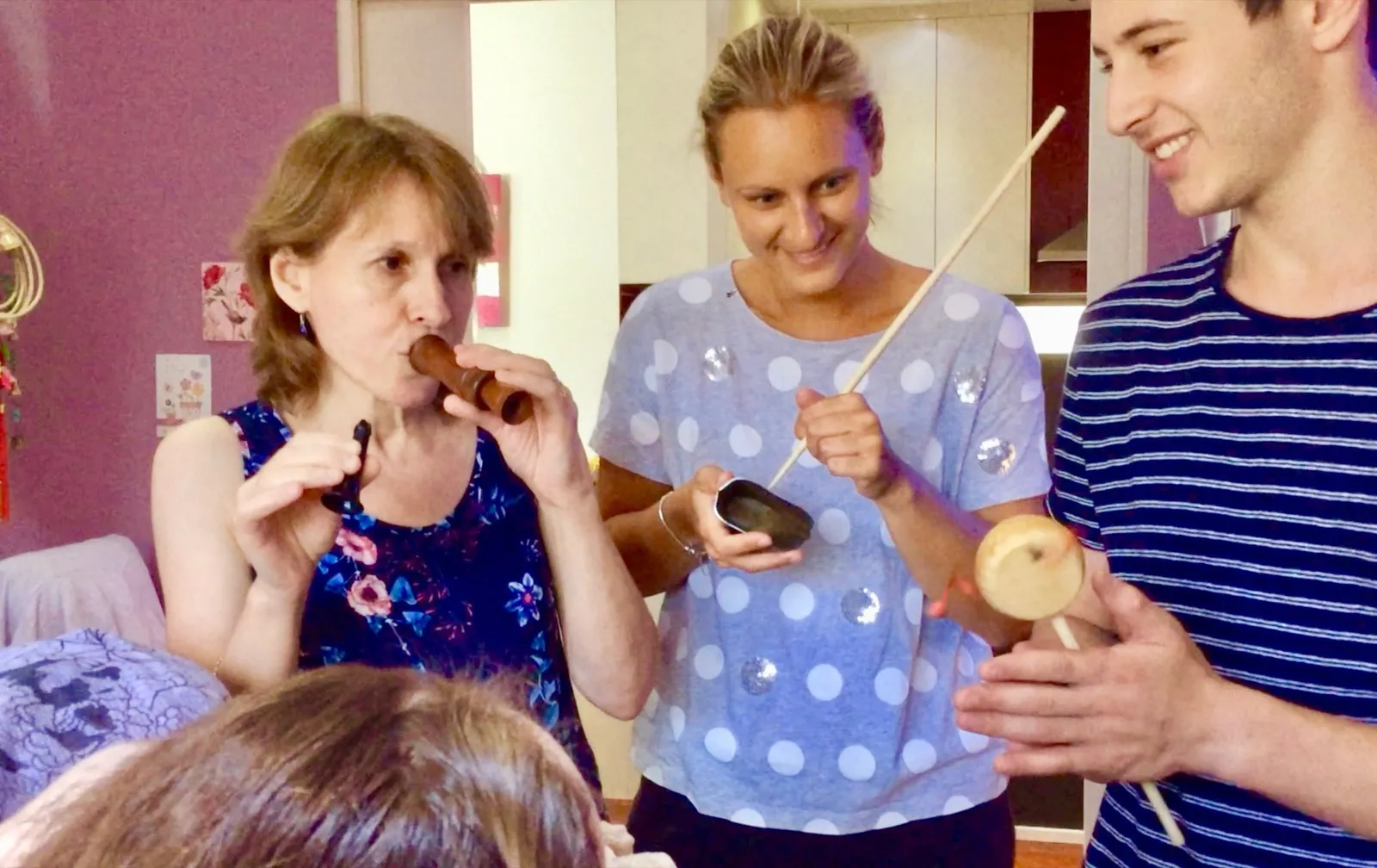 Family members playing wooden flutes and hand percussion together at home